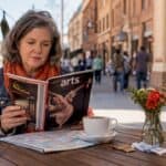 Woman reading arts publication in cafe