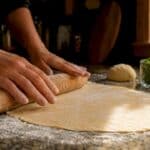 Hands kneading pasta dough in cooking class