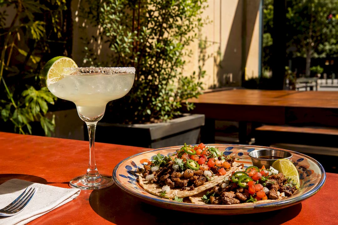 Tacos paired with margarita on patio table