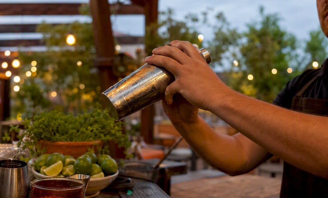 Bartender pouring classic margarita into glass
