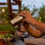 Bartender pouring classic margarita into glass
