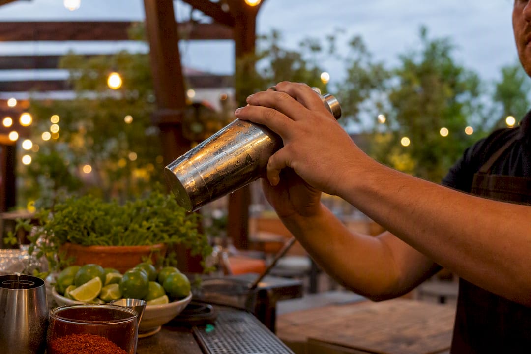 Bartender pouring classic margarita into glass
