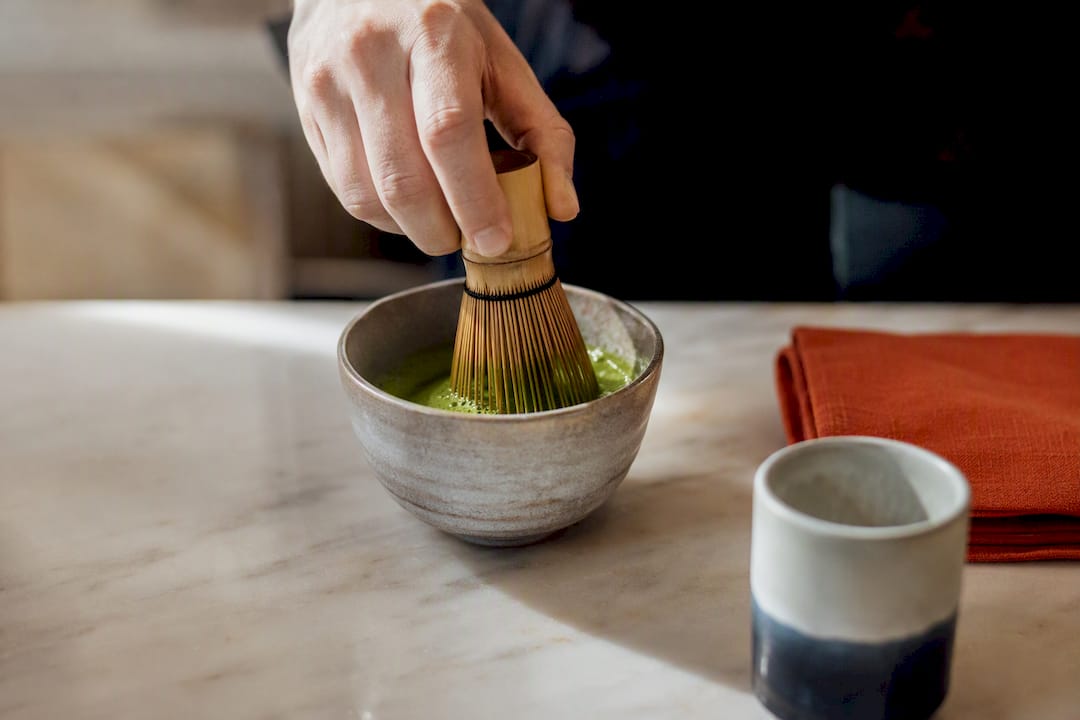 Matcha being whisked in ceramic bowl