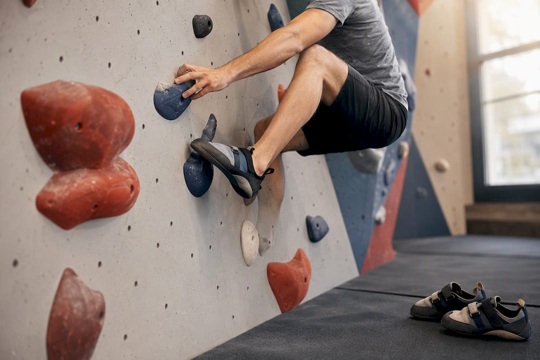 Climber navigating indoor bouldering wall