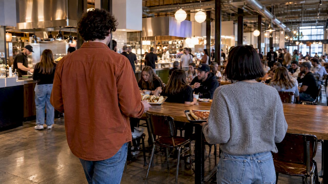 Diners carrying food through Strang Hall