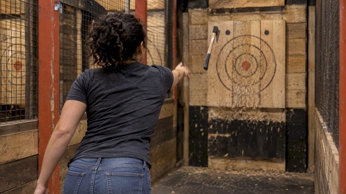 Thrower aiming at an indoor axe target