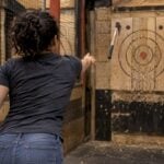 Thrower aiming at an indoor axe target