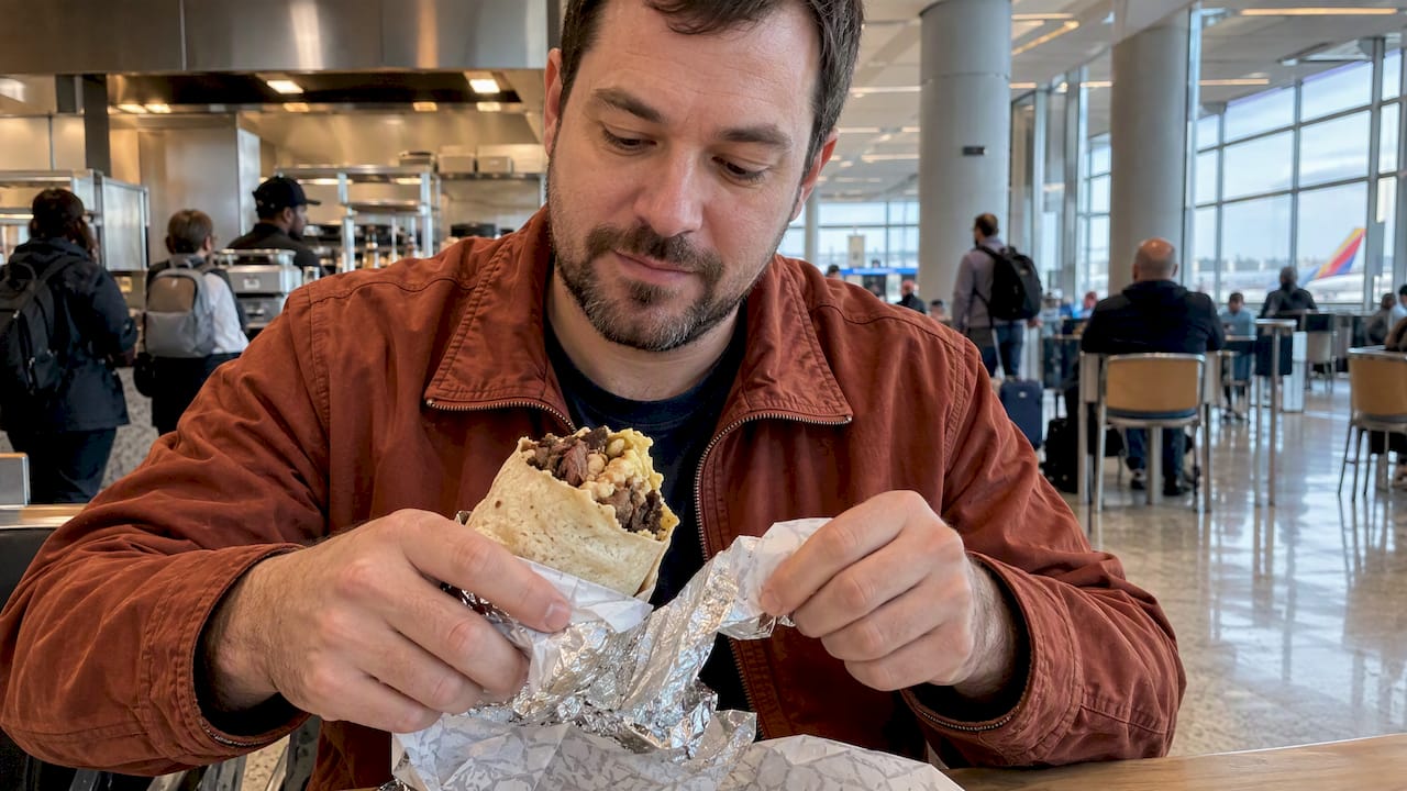 Traveler with a brisket burrito at KCI